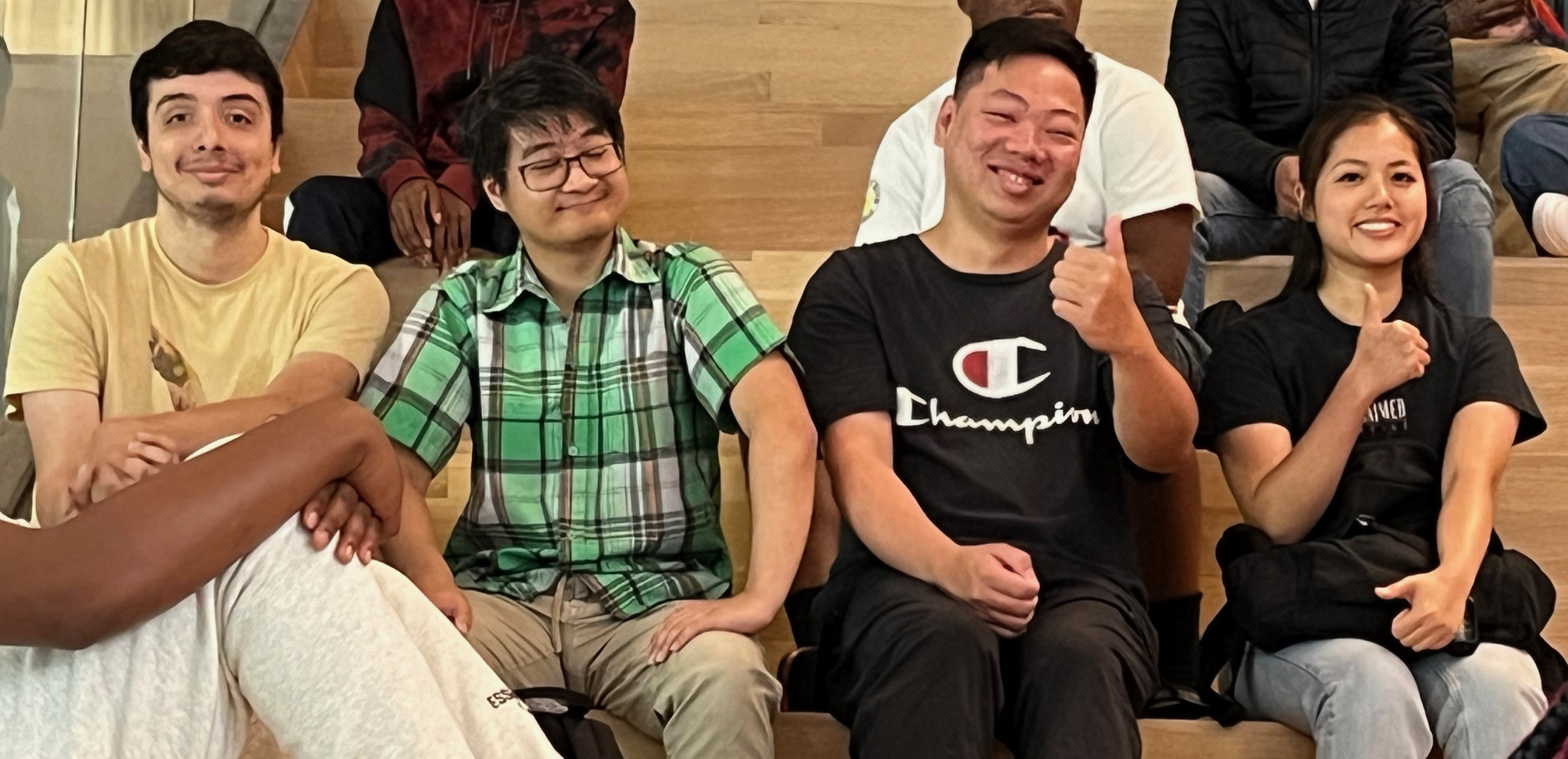 Students sitting on bleachers smiling.