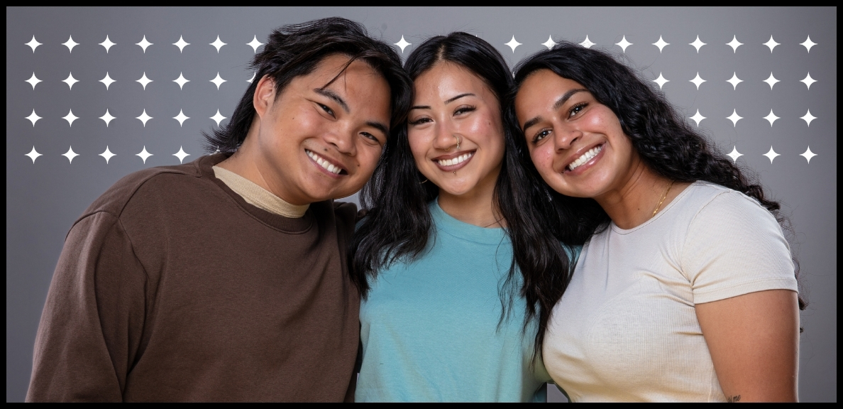 Three students smiling and standing close together showing that we are a supportive community