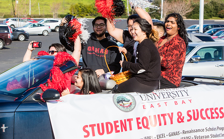 Students ride in car during parade