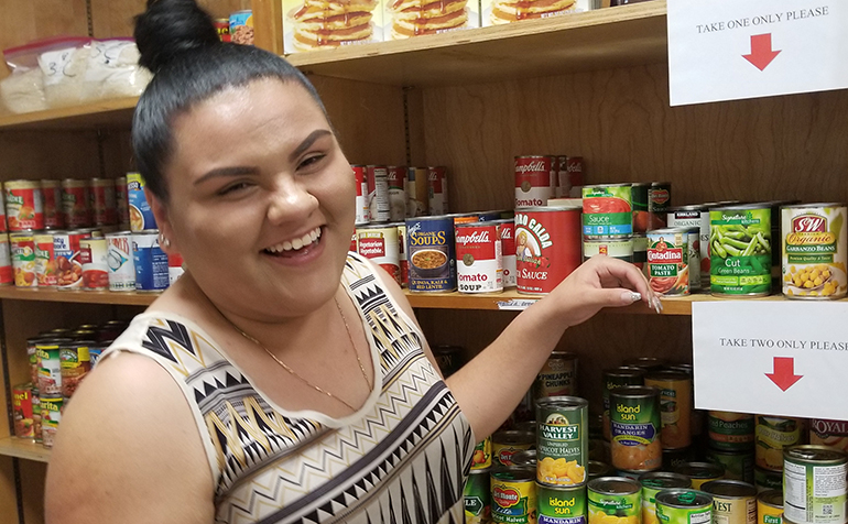 Woman selects canned goods from food pantry