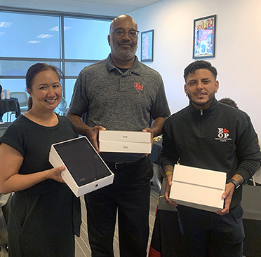 Three Cal State East Bay staff distribute iPads