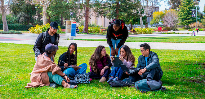 Students sitting on a Hayward campus lawn