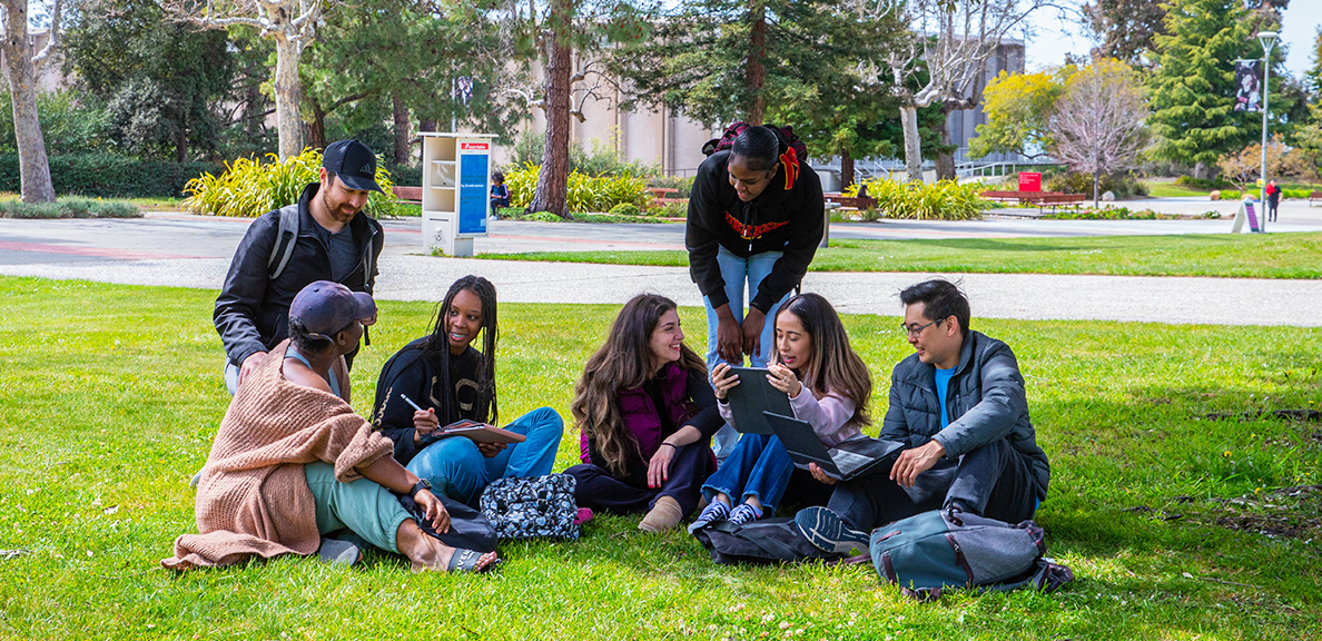 Students sitting on a Hayward campus lawn