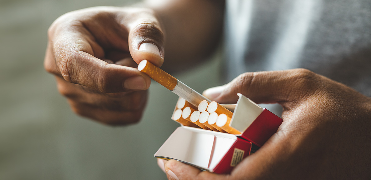 Close-up of a man holding a pack of cigarettes