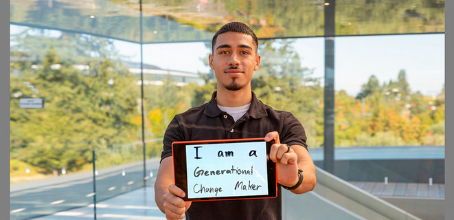 Wolfgang Mundt holding a small whiteboard that reads "I am a generational change-maker"