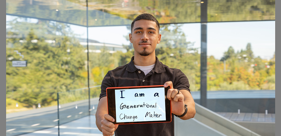 Wolfgang Mundt holding a small whiteboard that reads "I am a generational change-maker"